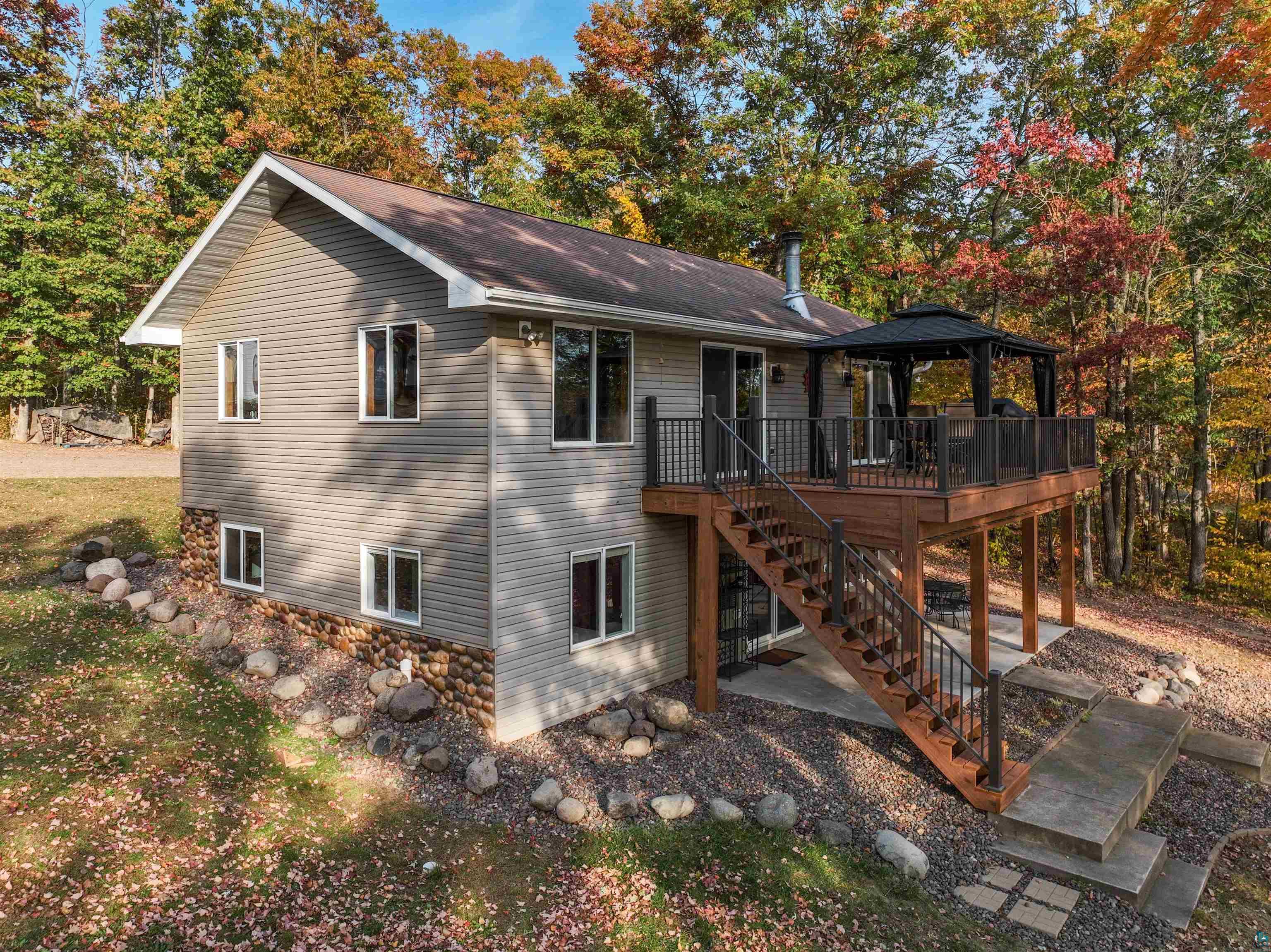 Back of property with a gazebo, a deck, and a patio