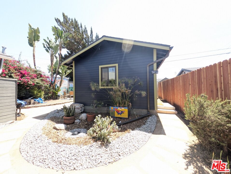 a view of a house with backyard sitting area and garden