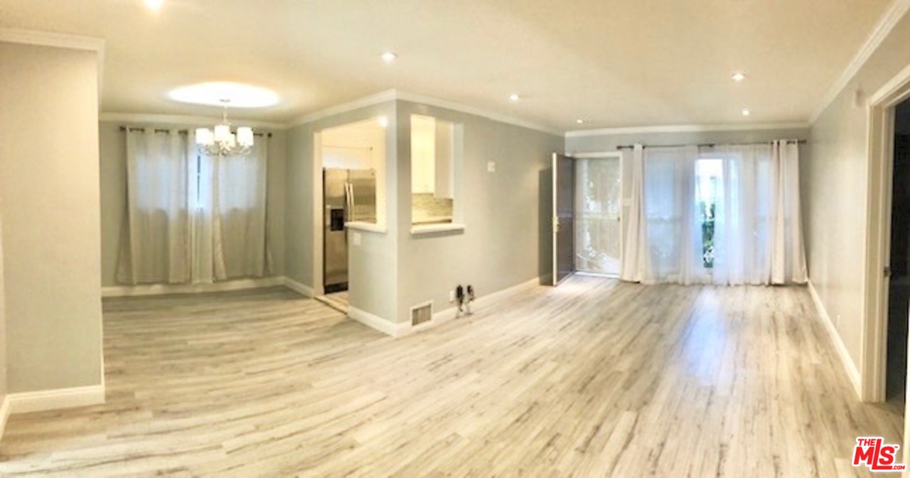 a view of empty room with wooden floor and windows