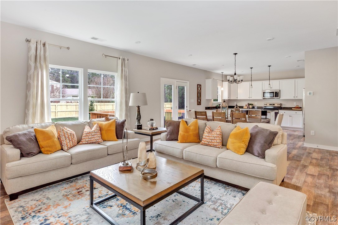 a living room with furniture kitchen view and a large window