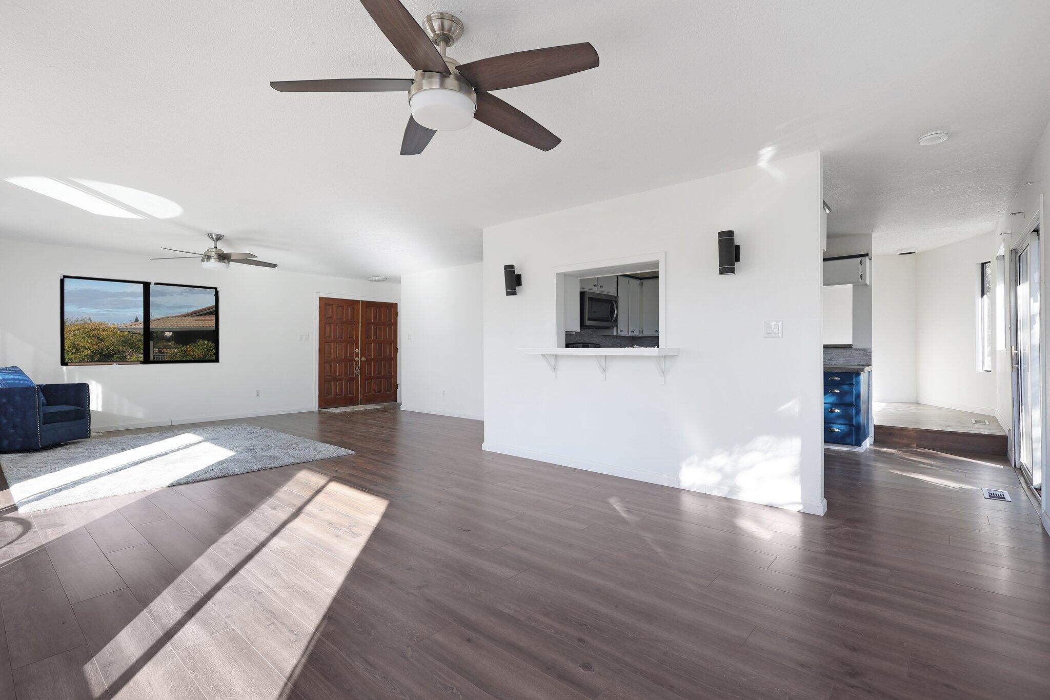 a view of a livingroom with wooden floor and a ceiling fan