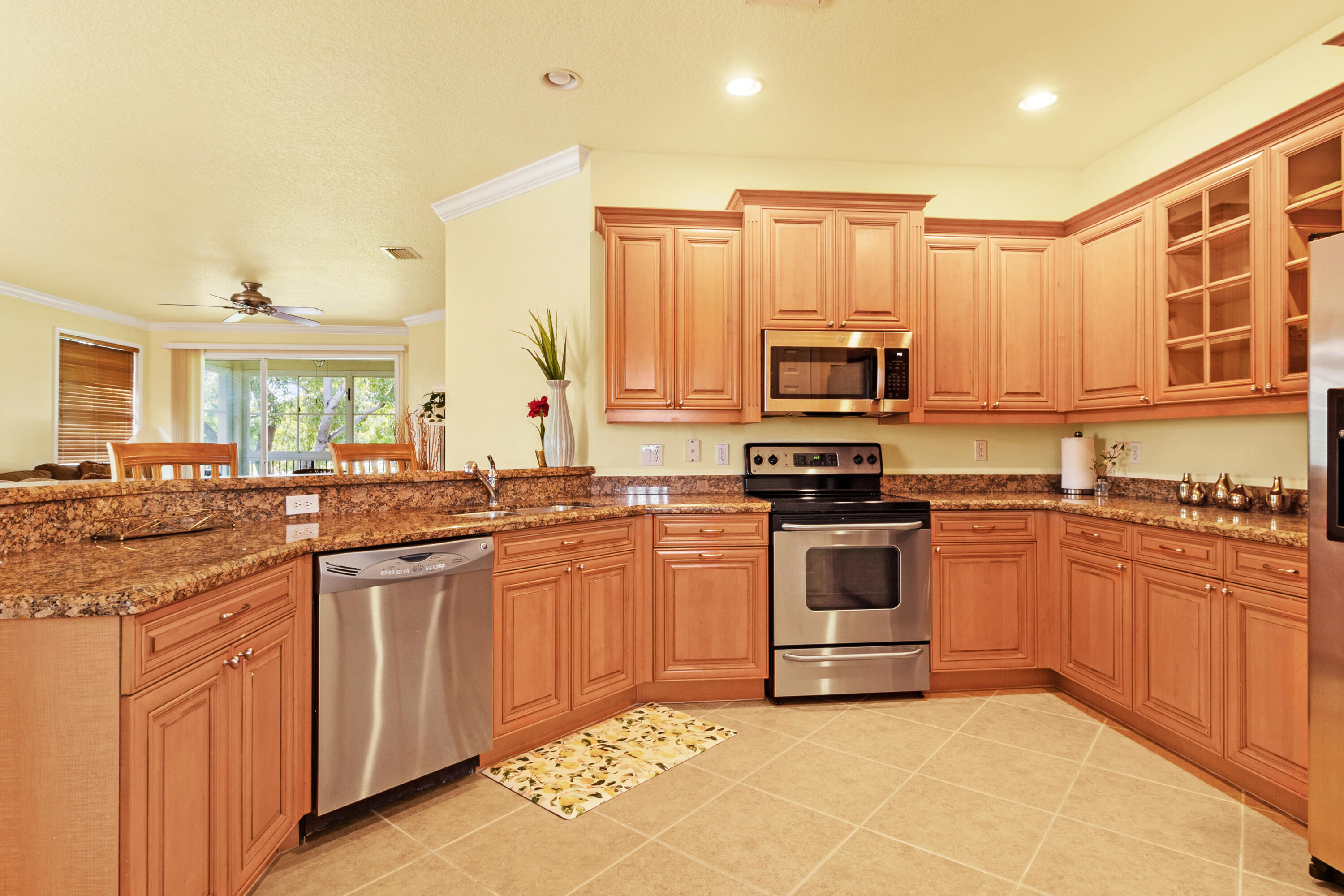 a kitchen with stainless steel appliances granite countertop a stove top oven a sink dishwasher and a refrigerator