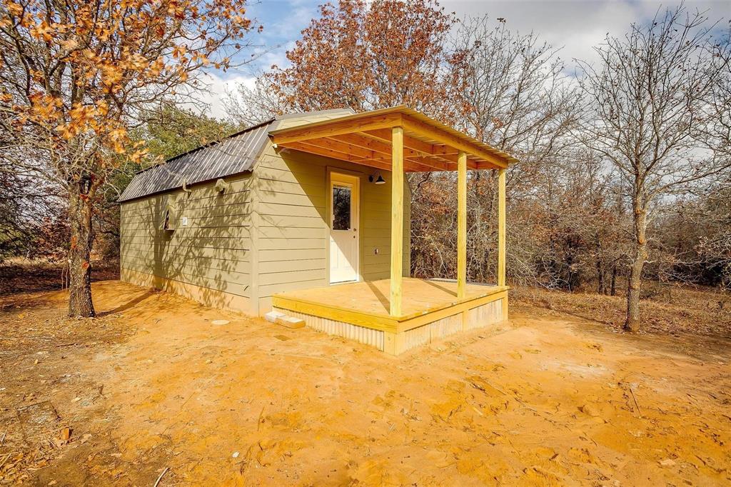 a view of wooden house with a yard