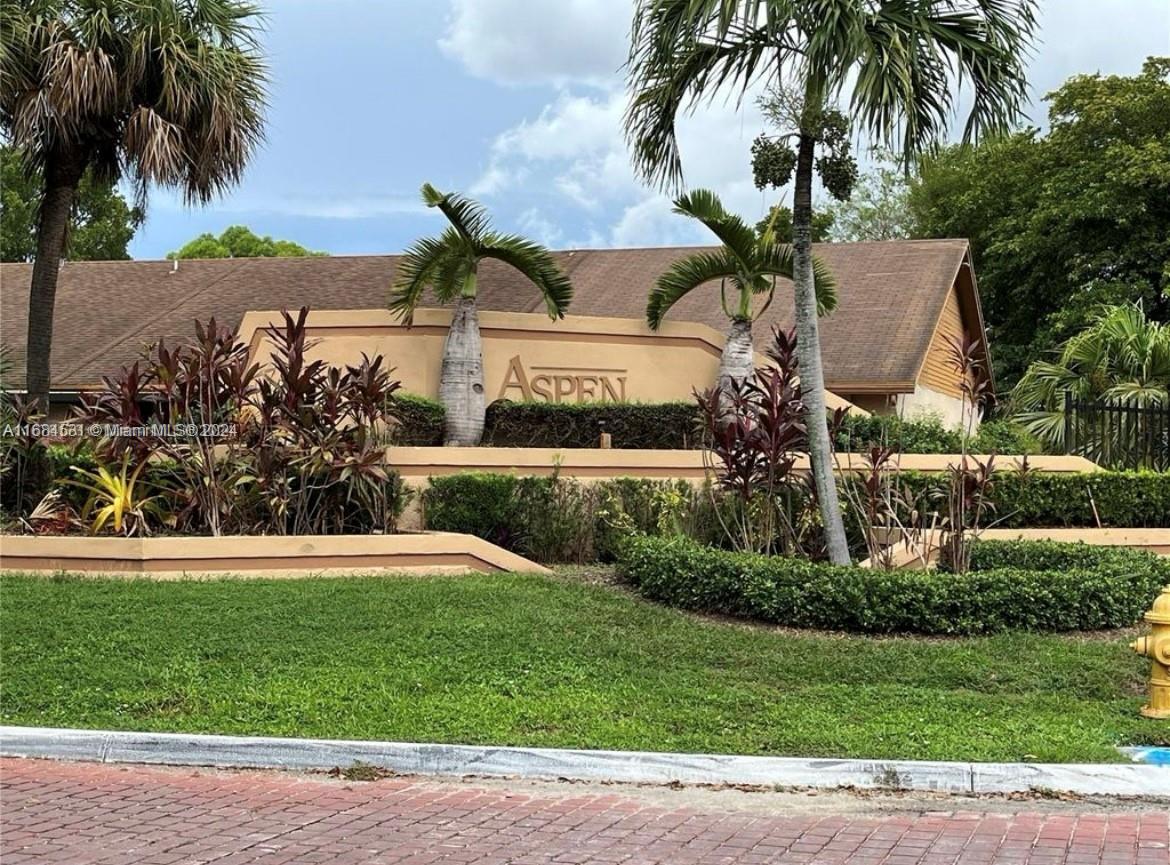 a front view of a house with a garden and tree