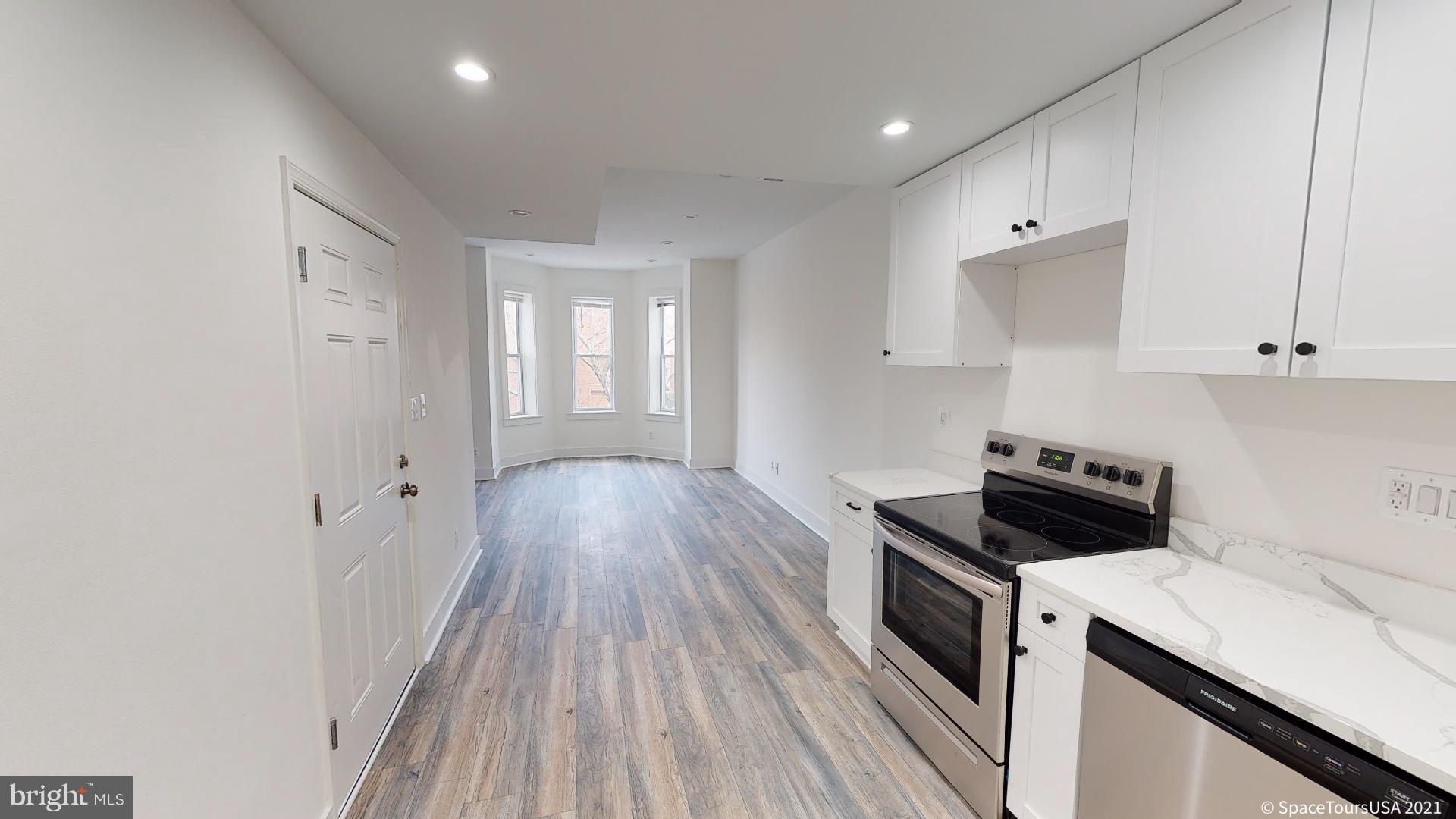 a kitchen with a stove and white cabinets