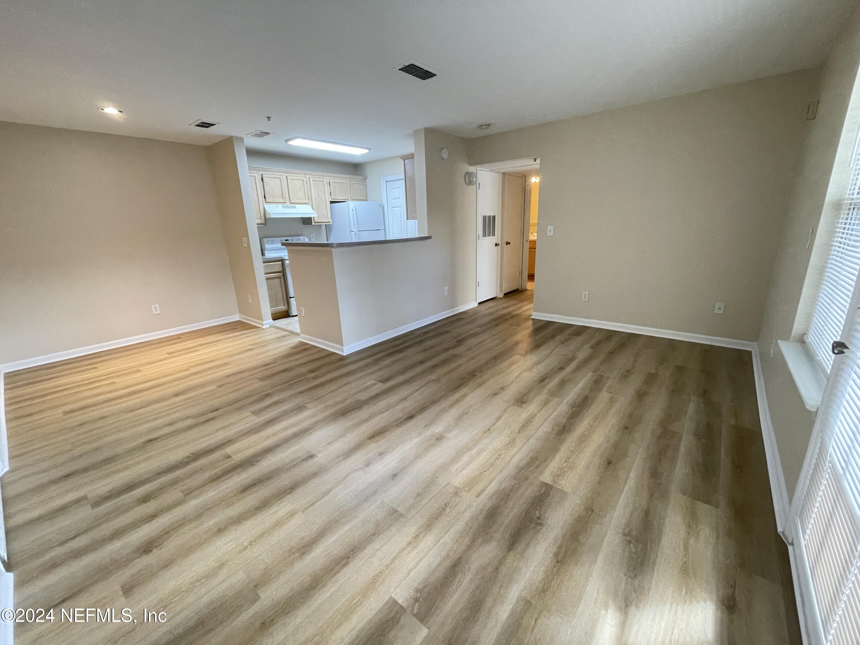 a view of a kitchen with a sink and wooden floor