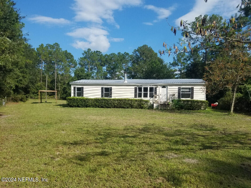 a front view of house with yard and trees