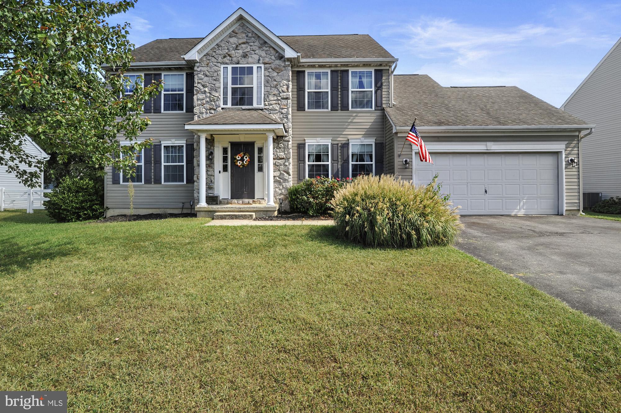 a front view of a house with a garden and yard