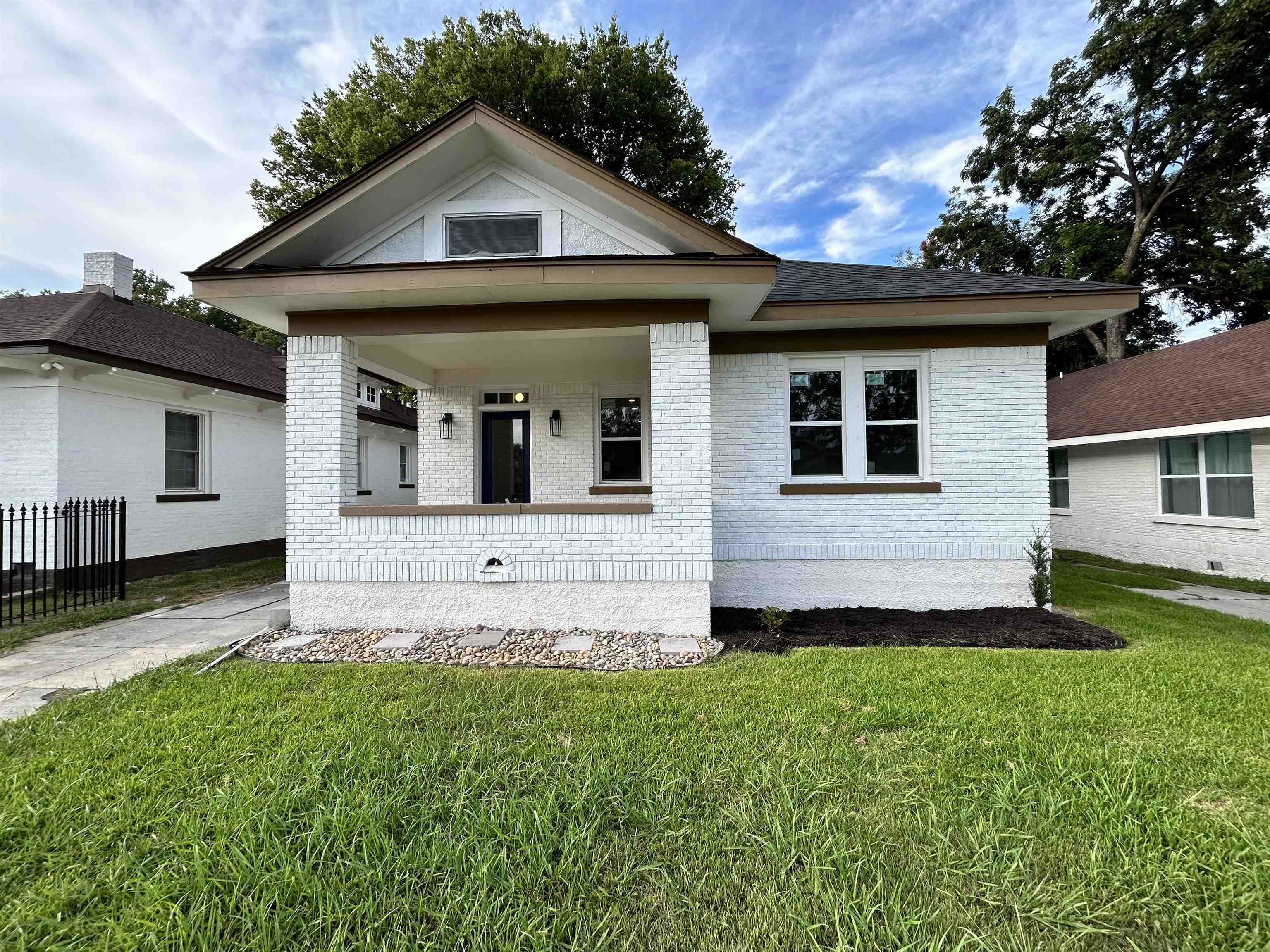 View of front facade with a front lawn and a porch