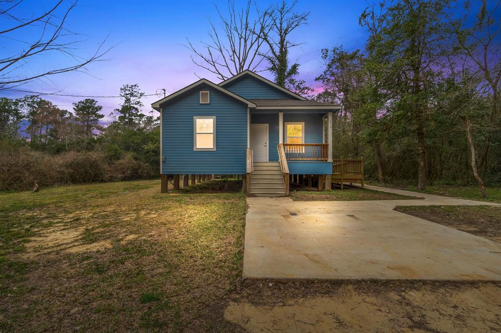 a view of a house with backyard and trees