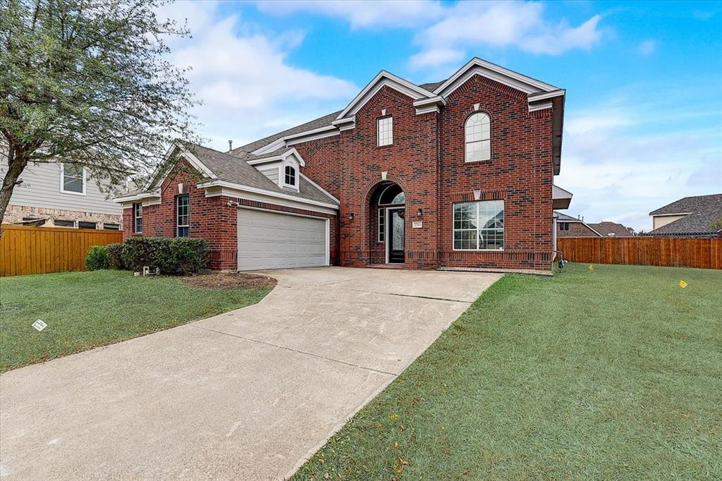 a front view of a house with a yard and garage