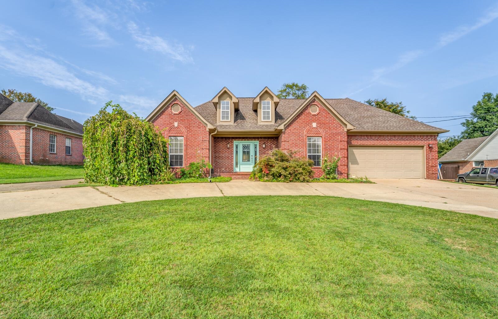 a front view of a house with a garden and yard