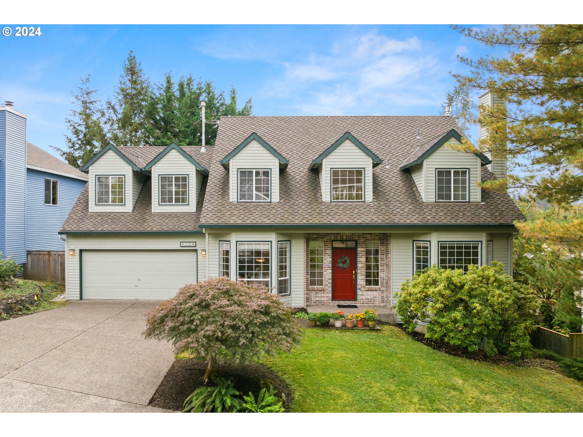 a front view of a house with a garden