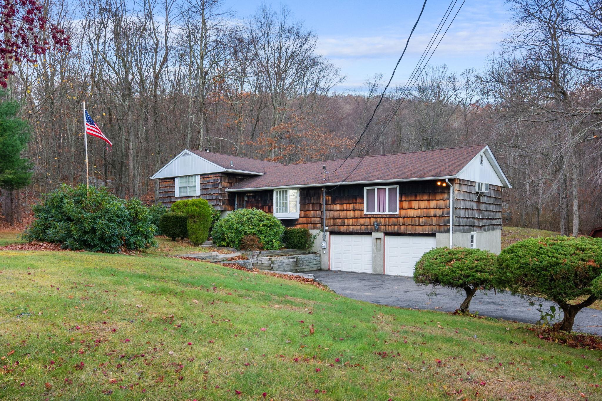 a front view of a house with a yard and trees