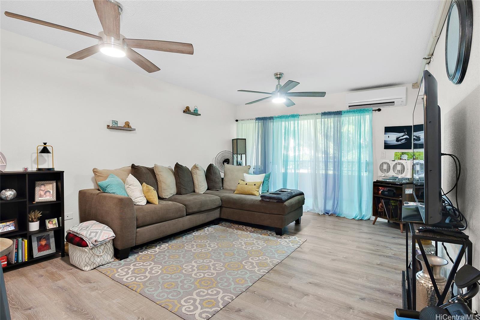 a living room with furniture a ceiling fan and a window