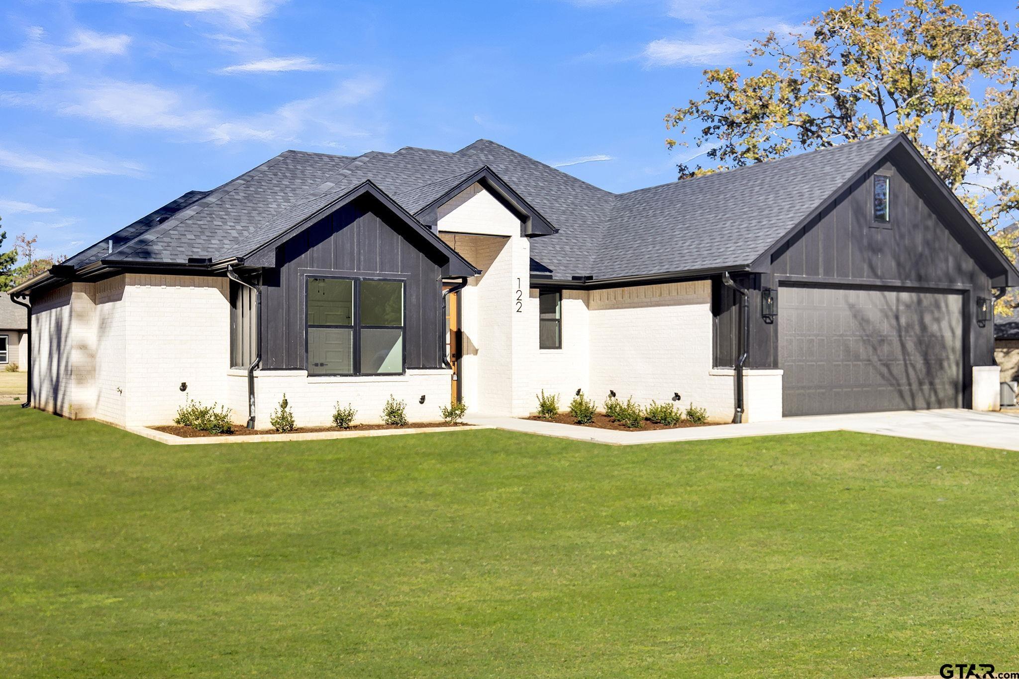 a view of a house with a big yard and garage