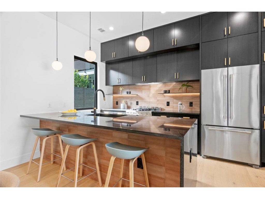 a kitchen with kitchen island a counter top space cabinets and stainless steel appliances