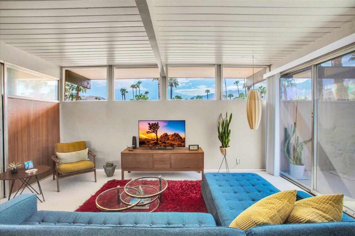 a living room with patio furniture and a large window