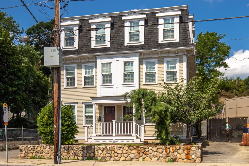 a front view of a building with a tree