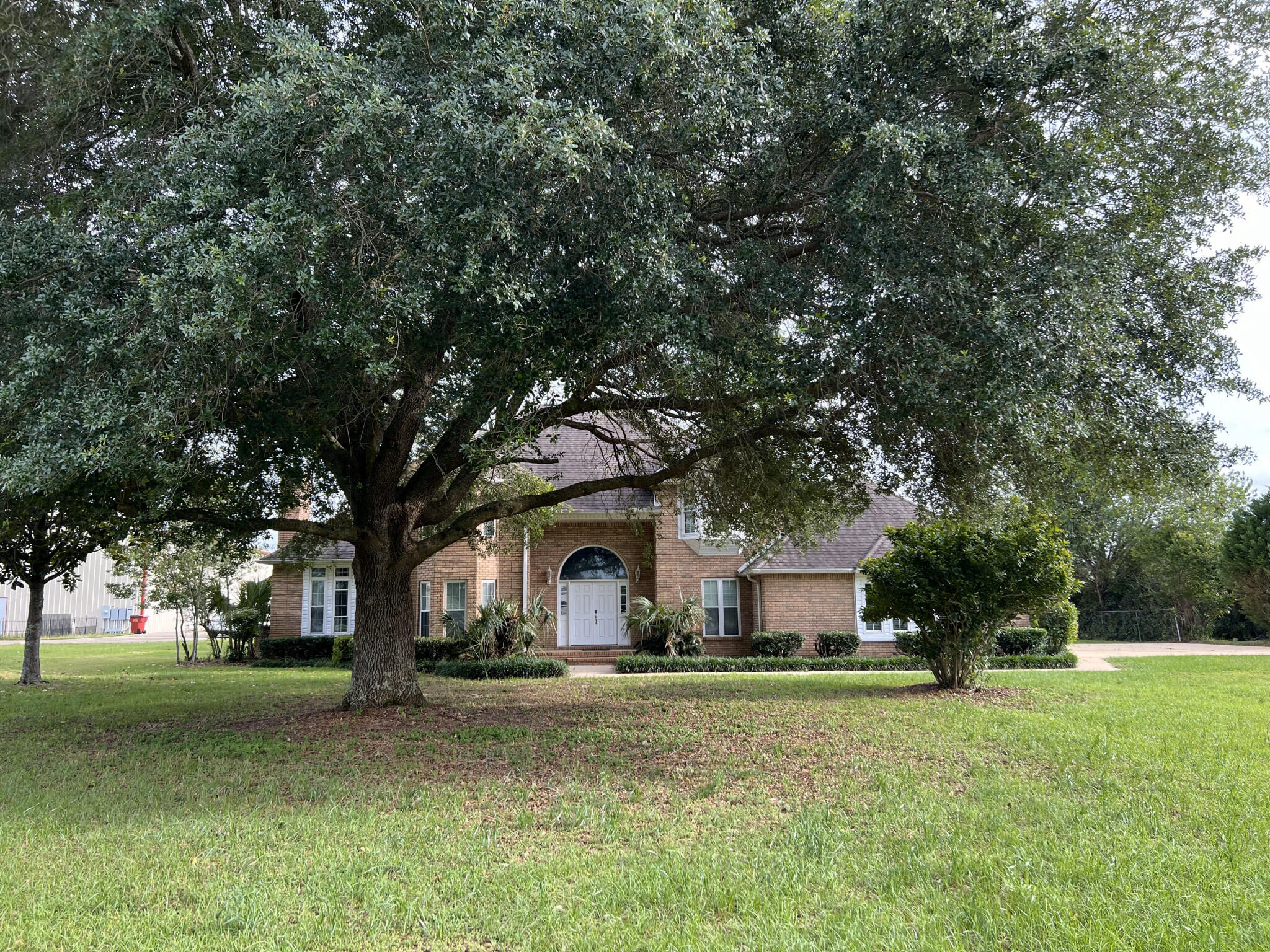 a front view of a house with a garden and tree