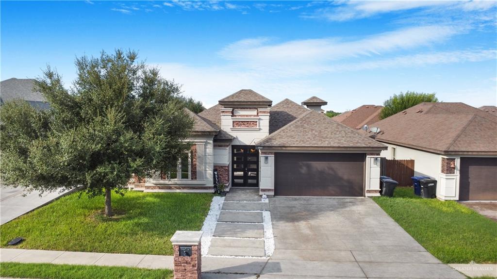 View of front of house with a front yard and a garage