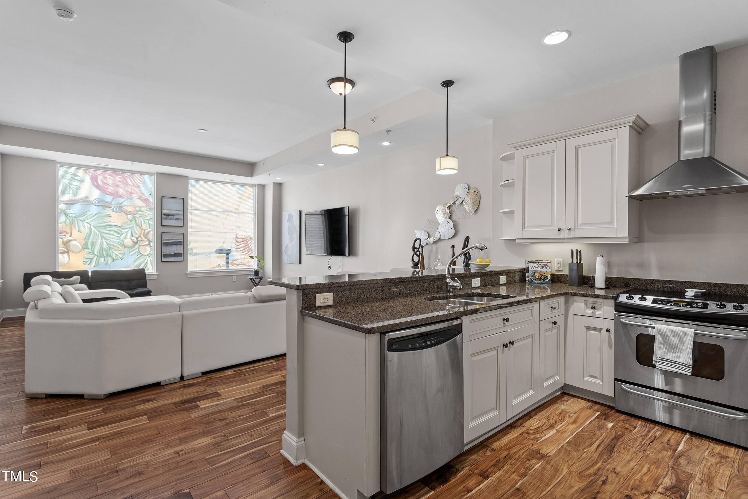 a kitchen with stainless steel appliances granite countertop a stove a sink and a refrigerator