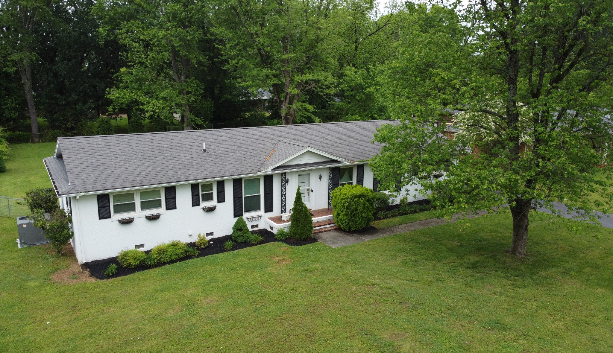 a aerial view of a house with a yard table and chairs