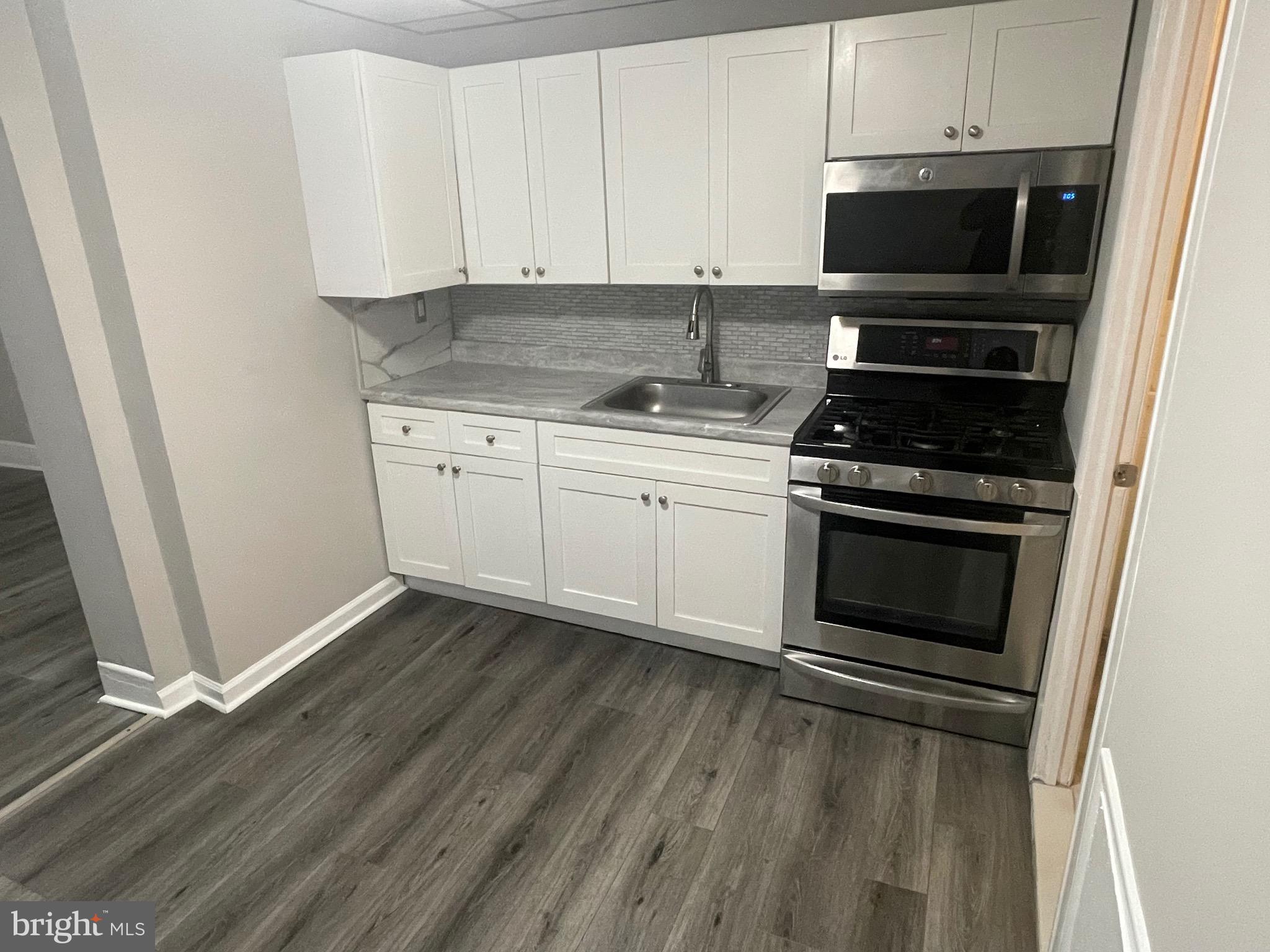 a kitchen with granite countertop a stove and a microwave