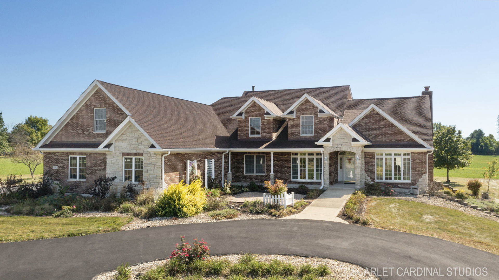 a front view of a house with a garden and yard