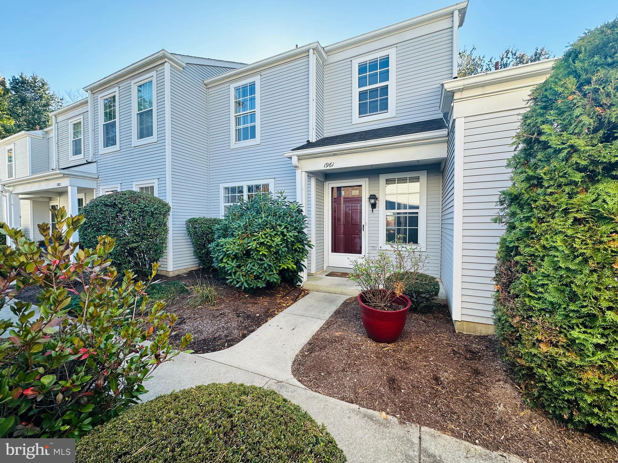 a front view of a house with a yard and potted plants