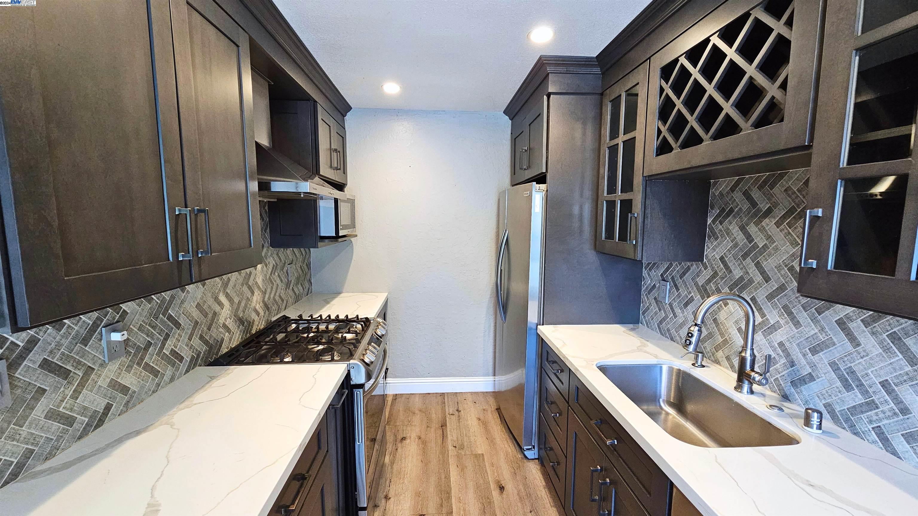 a kitchen with stainless steel appliances granite countertop a sink stove and refrigerator