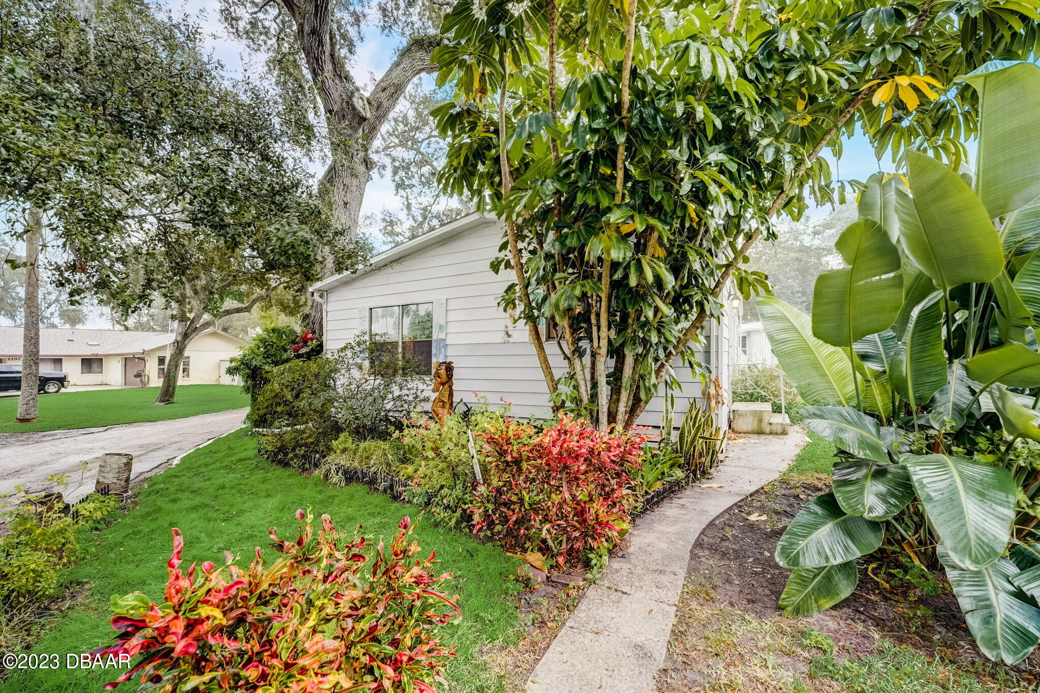 a front view of a house with a yard and fountain