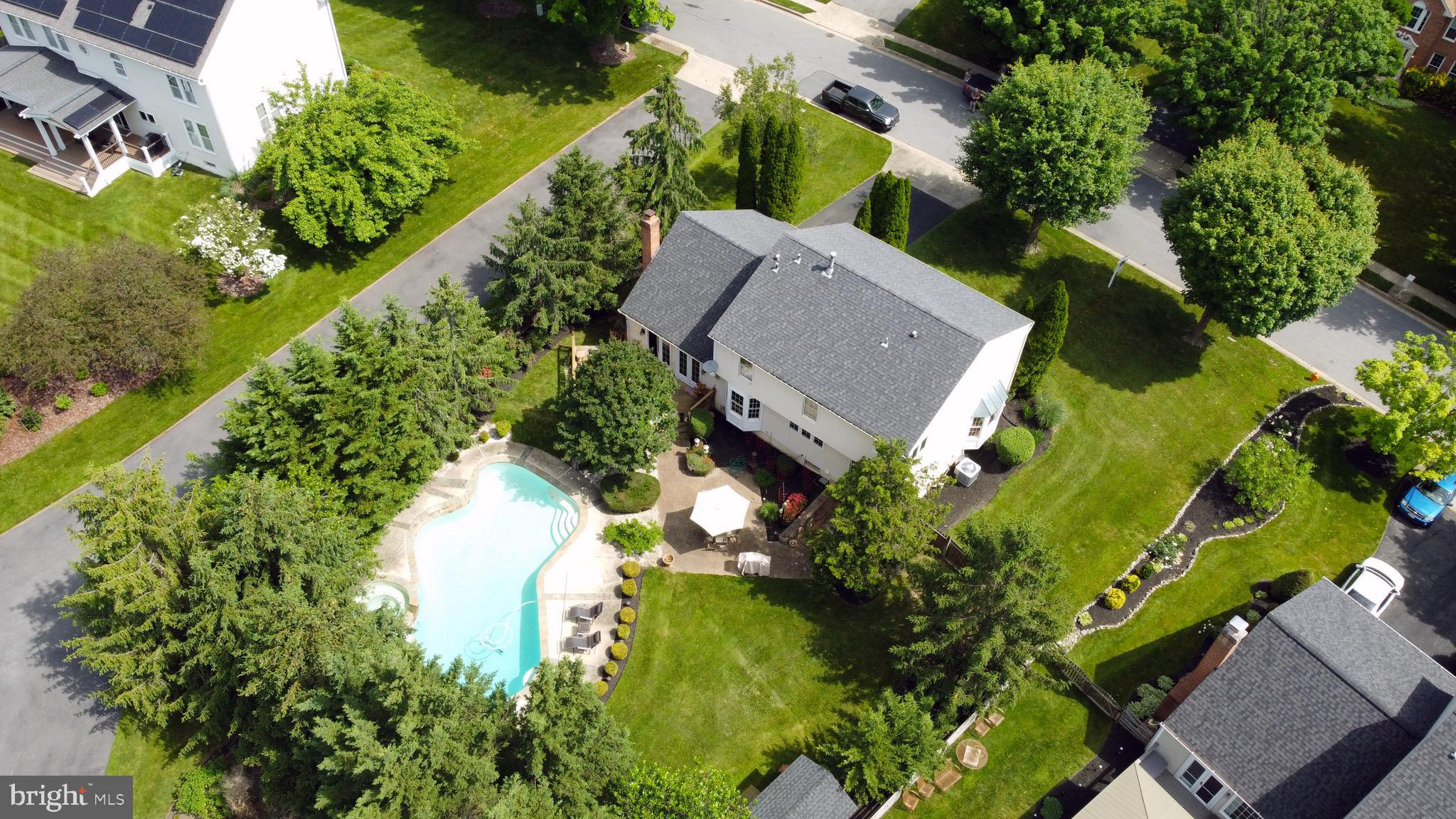 an aerial view of a house with a garden and swimming pool