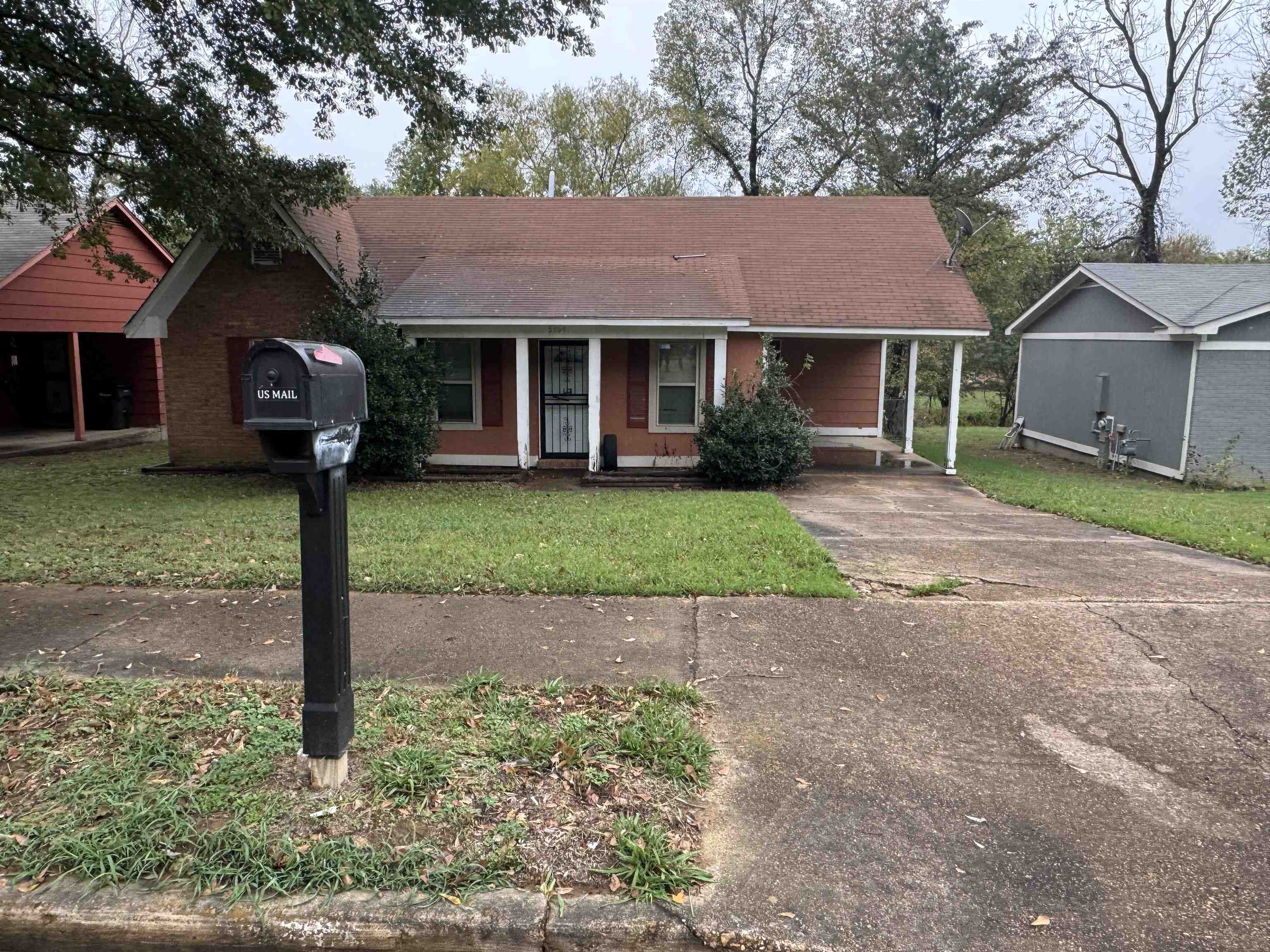 View of front of property featuring a front lawn and a carport