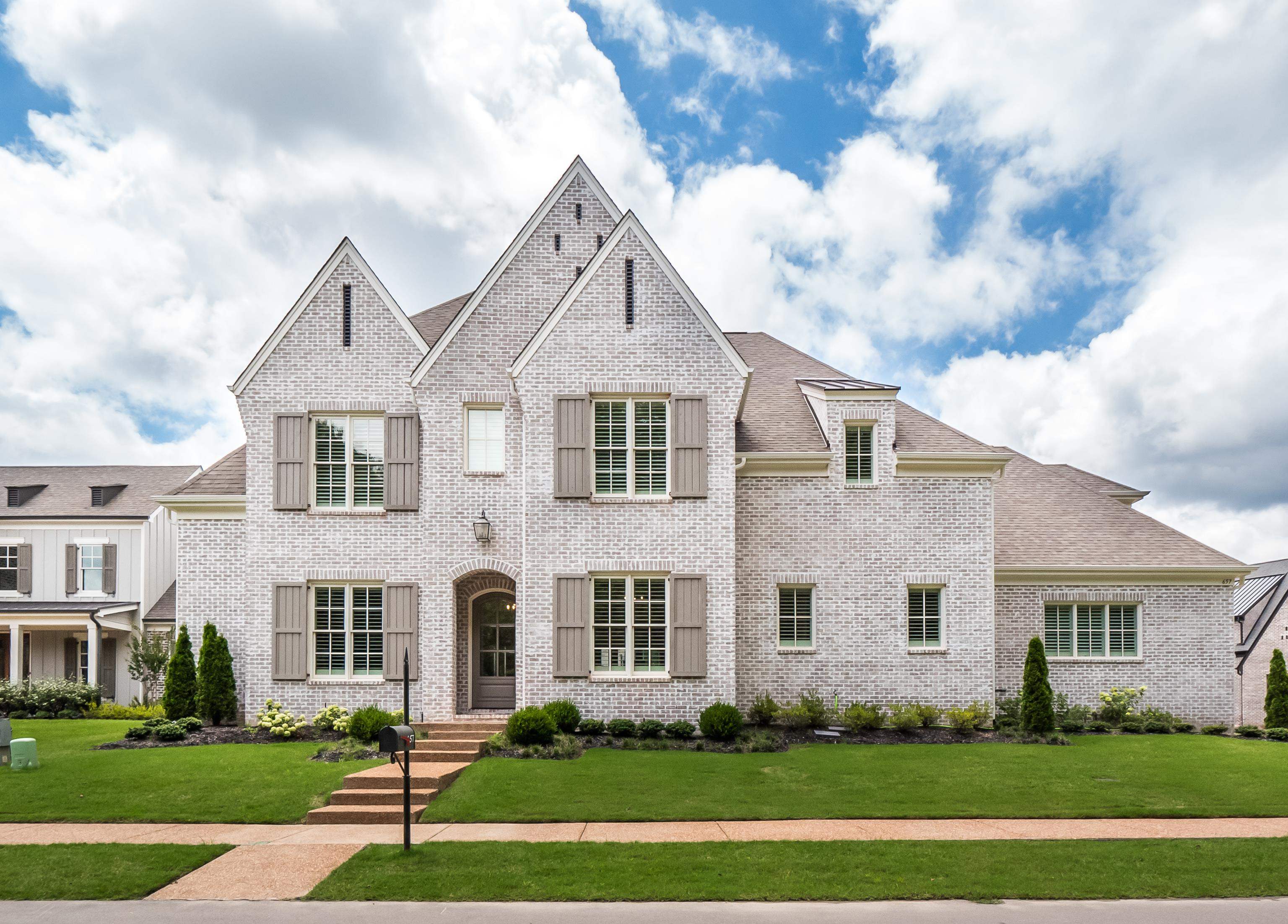 French country inspired facade featuring a front lawn