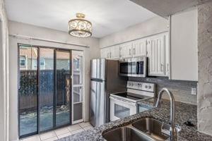 a kitchen with a refrigerator a sink and a stove top oven