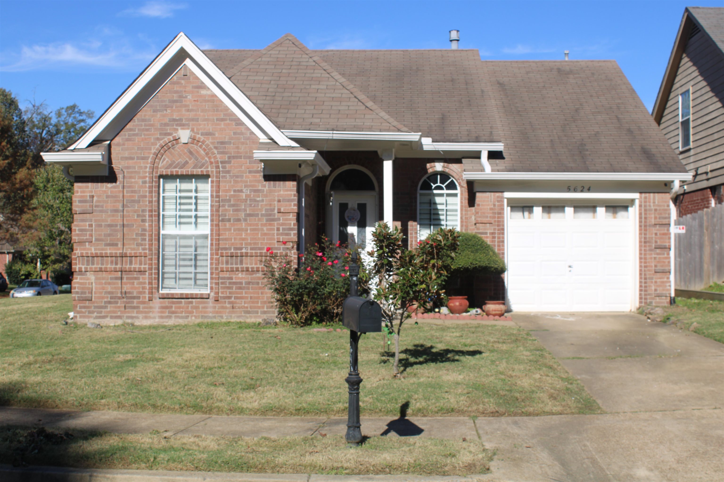 View of front of home with a front yard and a garage