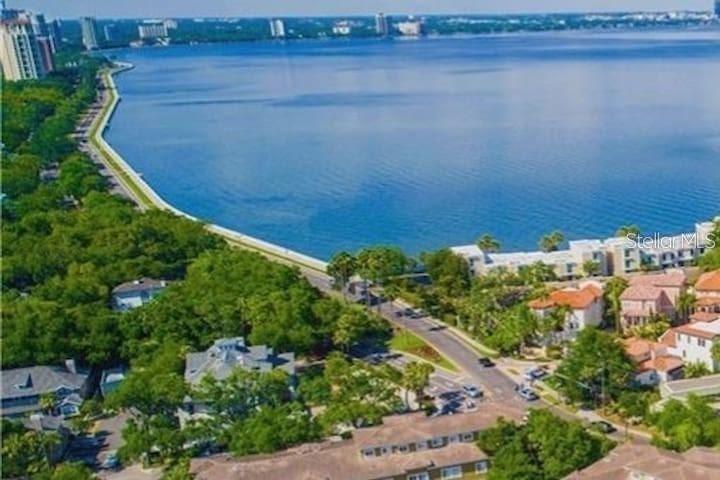 an aerial view of a house with a yard and lake view