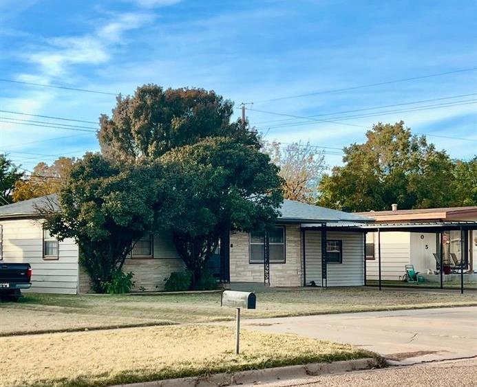 a front view of a house with a tree