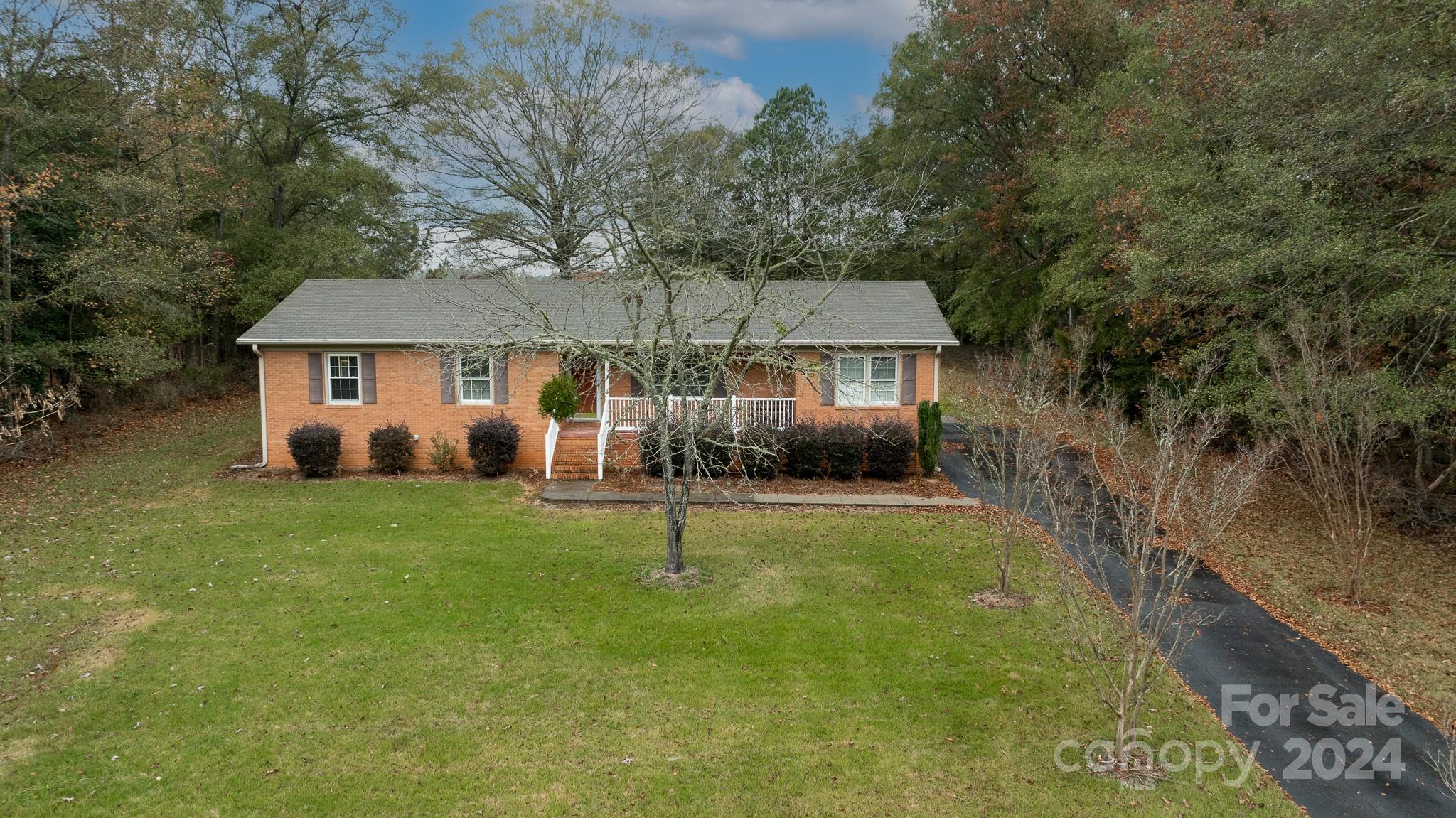 a view of a house with backyard and tree