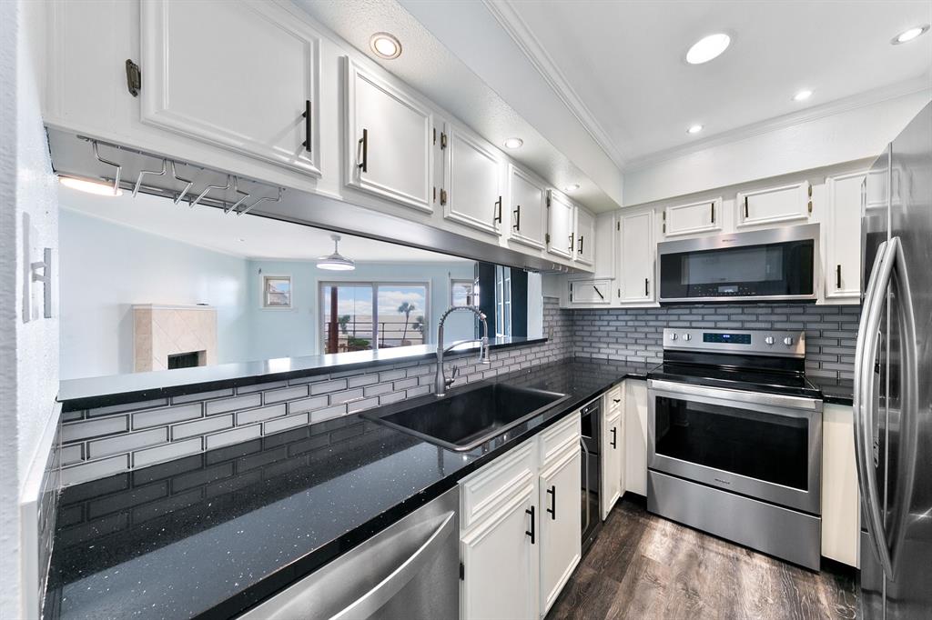 a kitchen with granite countertop a sink and stainless steel appliances