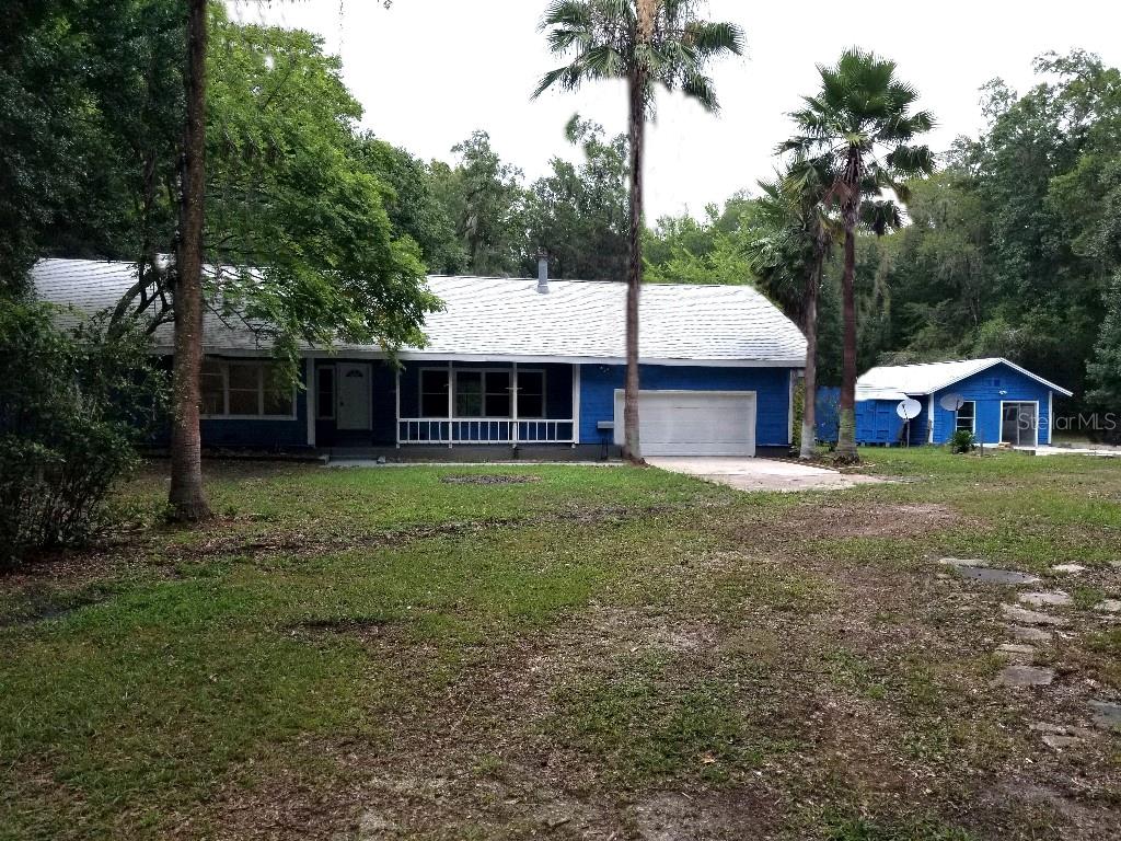 a front view of house with yard and green space