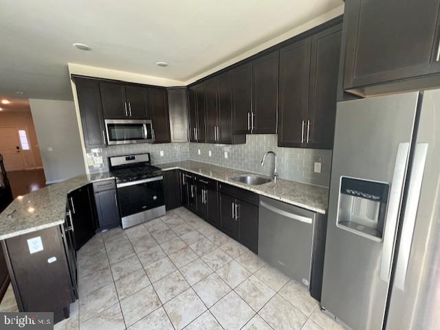 a kitchen with stainless steel appliances granite countertop a refrigerator stove top oven and sink