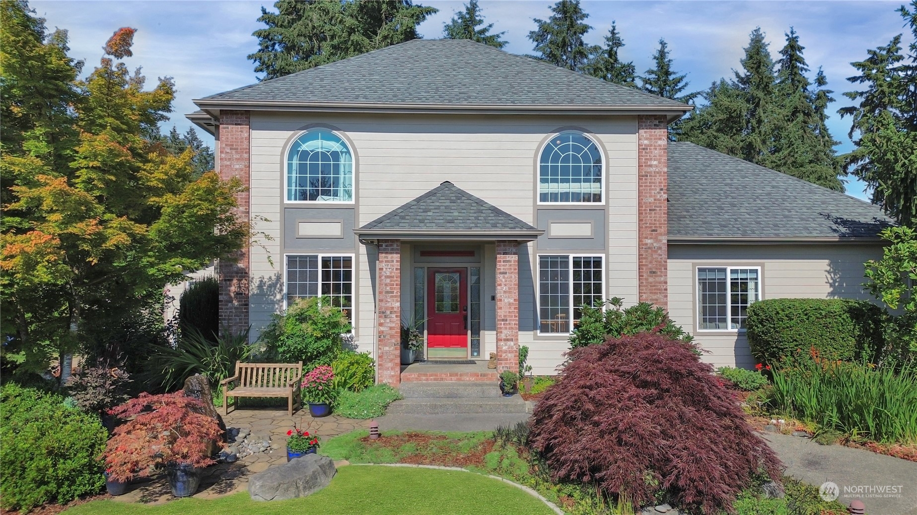 a front view of a house with a yard and plants