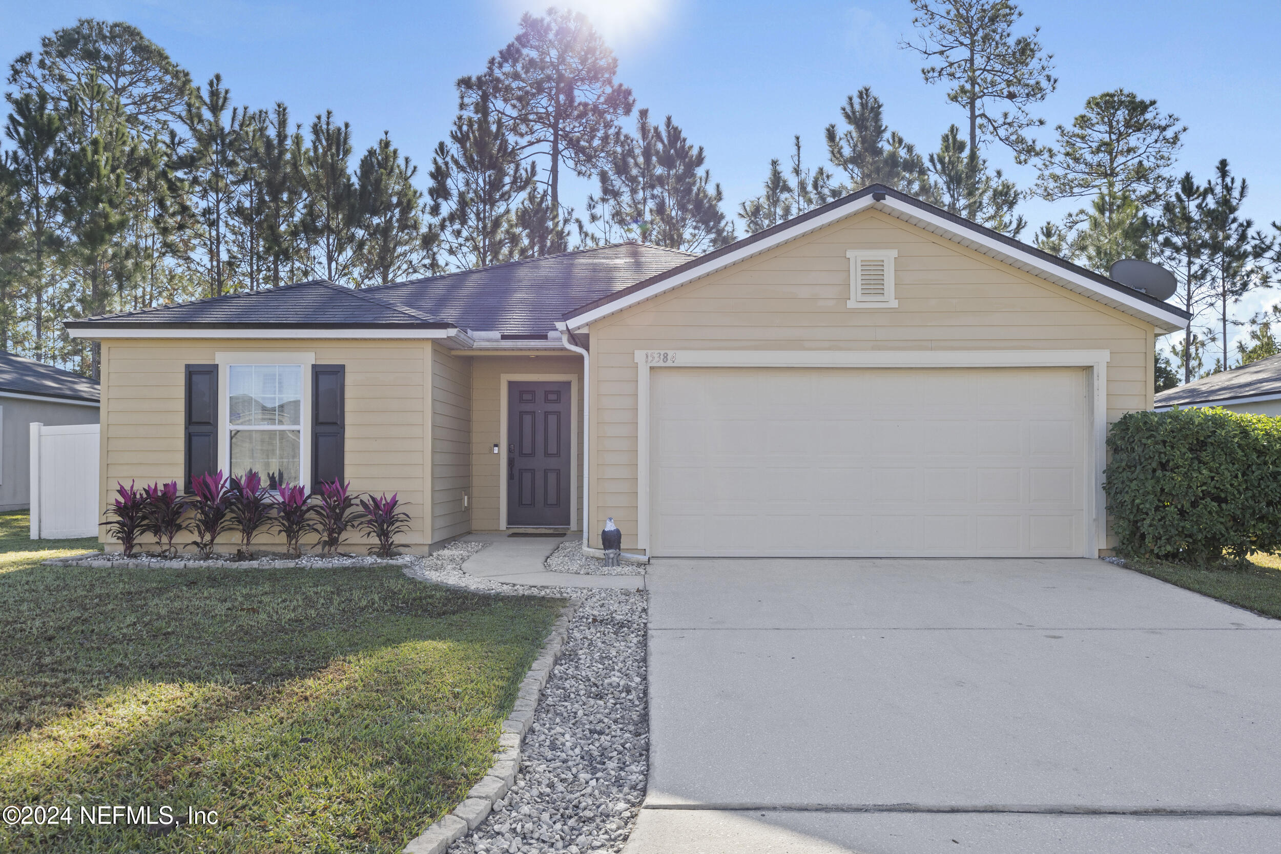 a front view of house with yard and trees in the background