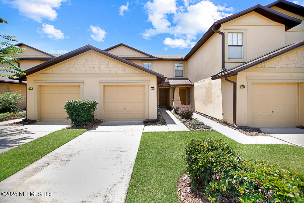 a front view of a house with a yard and garage