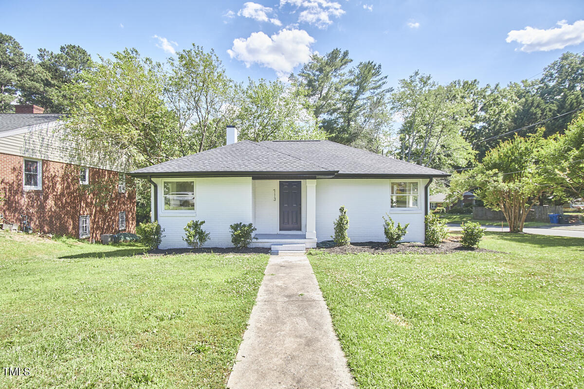 a front view of a house with a garden and yard