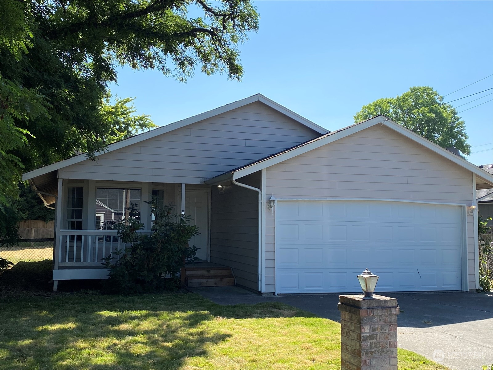 a front view of house with yard and trees in the background