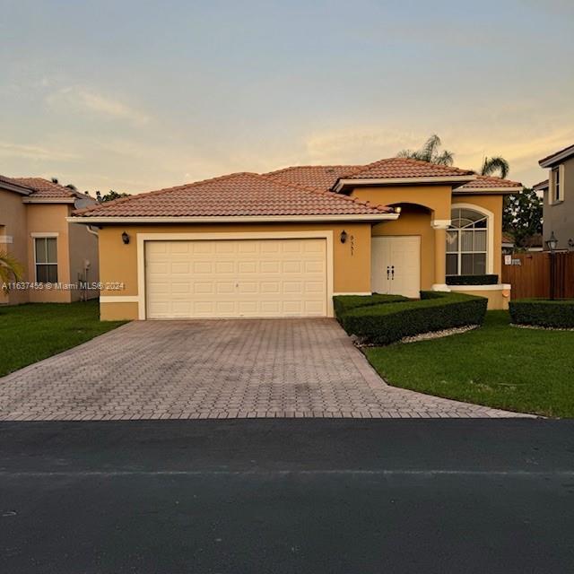 a front view of a house with a yard and garage