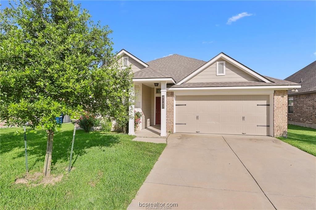 a front view of a house with a yard and garage